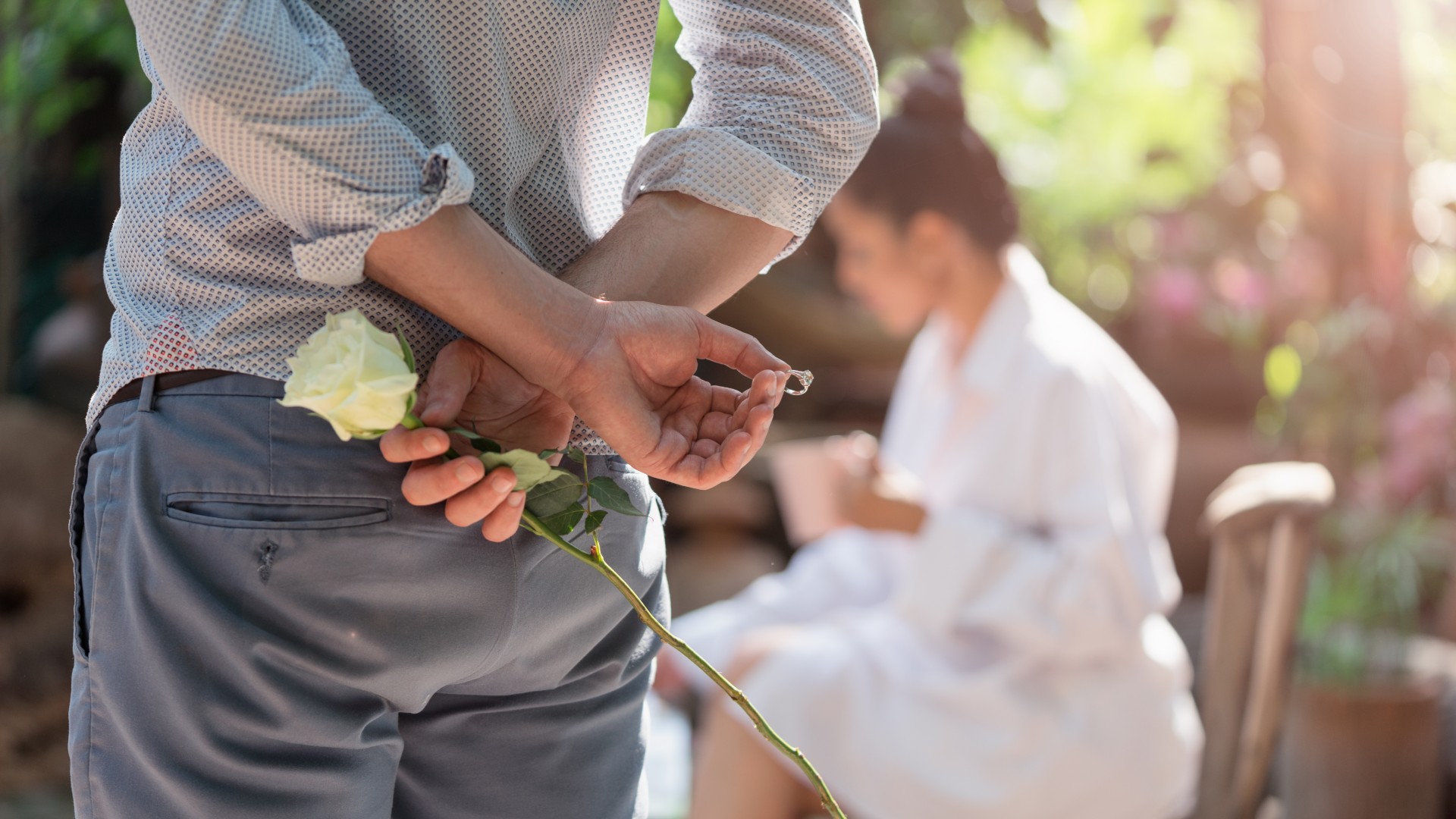 a man holds a ring behind his back